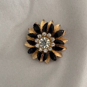 vintage black and gold-tone rhinestone flower brooch. 1” diameter.